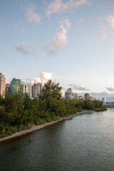 A serene Calgary cityscape with the Bow River at sunset, showcasing urban and natural beauty.