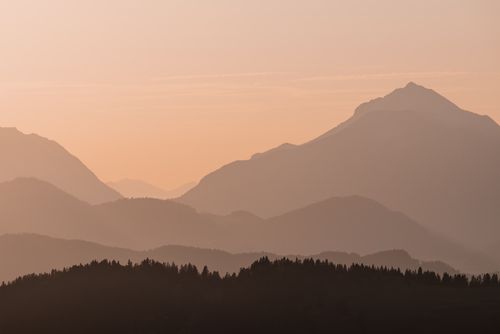 Free A tranquil sunrise view of layered mountains creating a peaceful and moody landscape. Stock Photo