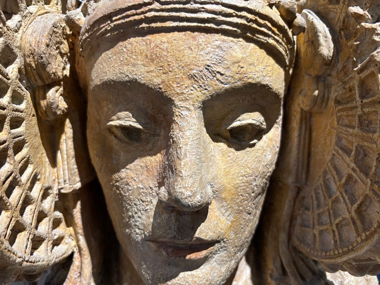 detailed close up of an ancient intricately carved stone statue in sun