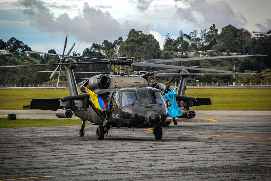 Black military helicopters on an airfield with vibrant flags, ready for mission.
