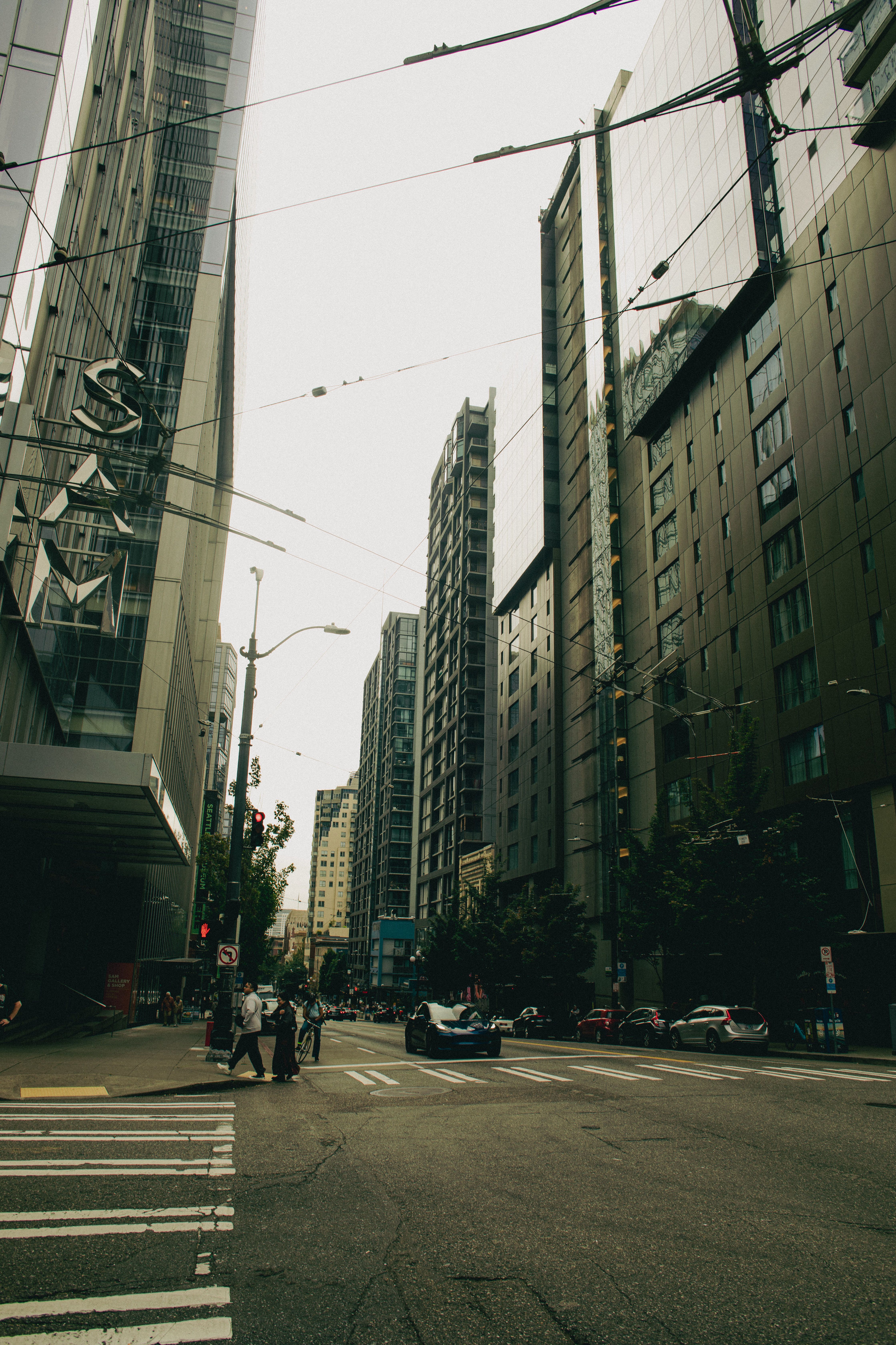 Urban street scene in Seattle with modern high-rise buildings and pedestrians crossing.