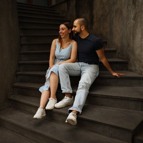 Free A smiling couple enjoying a moment together on an old stone staircase in Armenia. Stock Photo