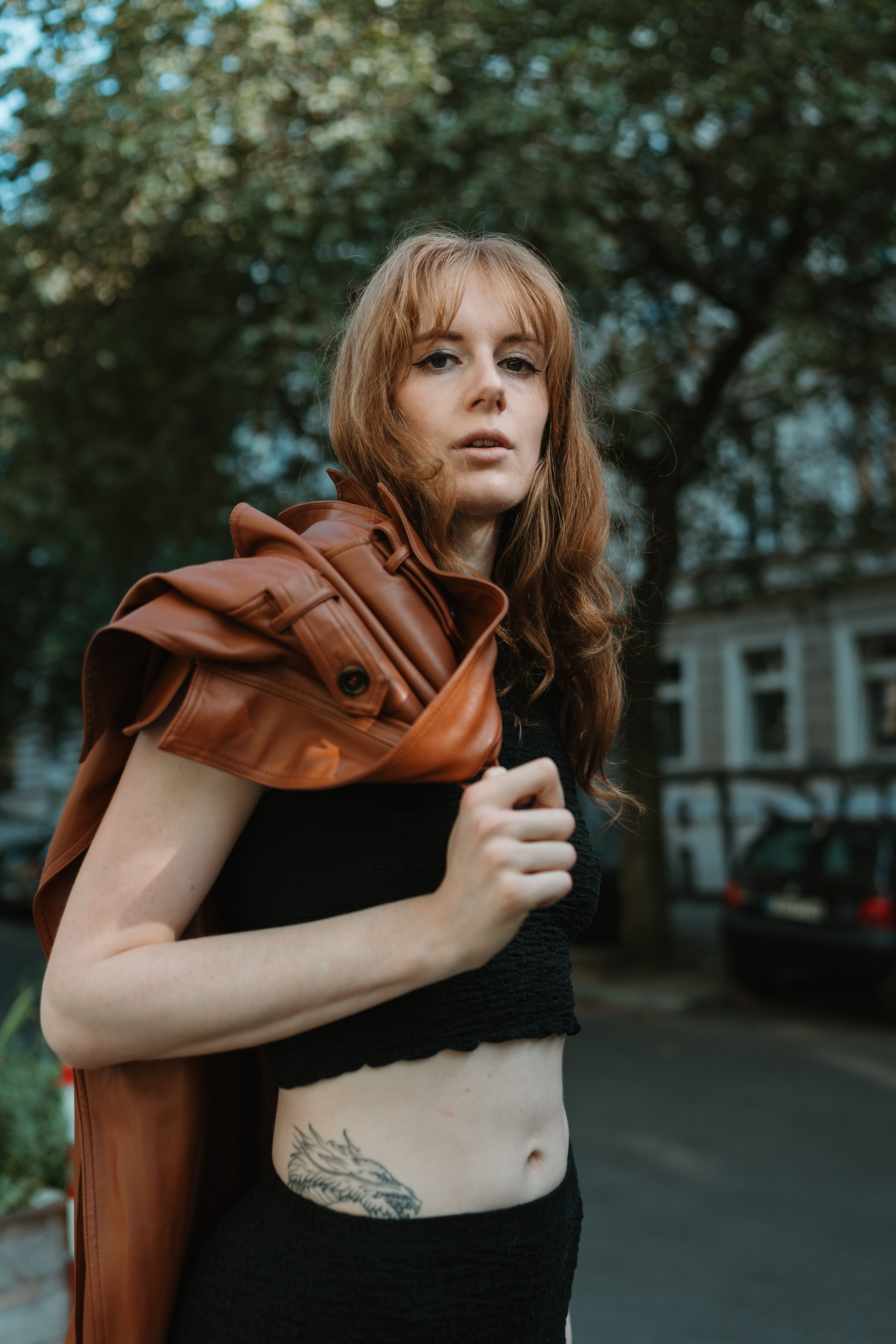 Captivating urban portrait of a young woman in Berlin, showcasing fashionable style with natural light.
