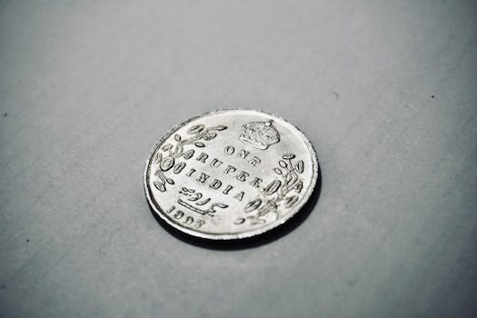 Close-up photograph of a 1907 silver Indian rupee coin with intricate details.