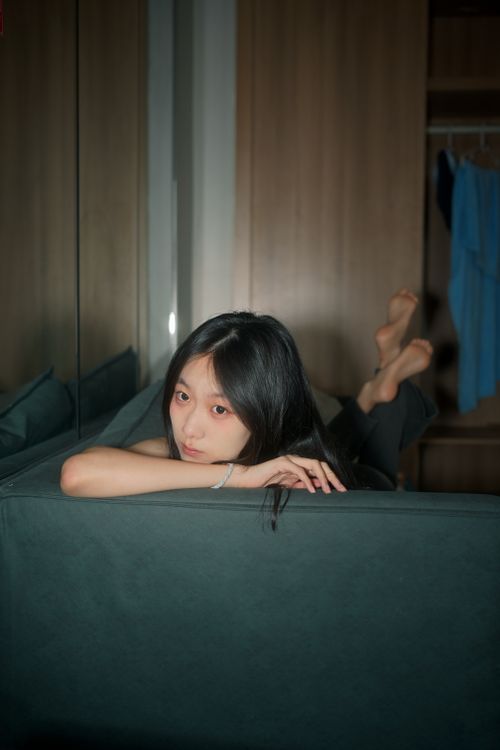 Free Young woman relaxing on a couch indoors, exuding a peaceful mood. Stock Photo