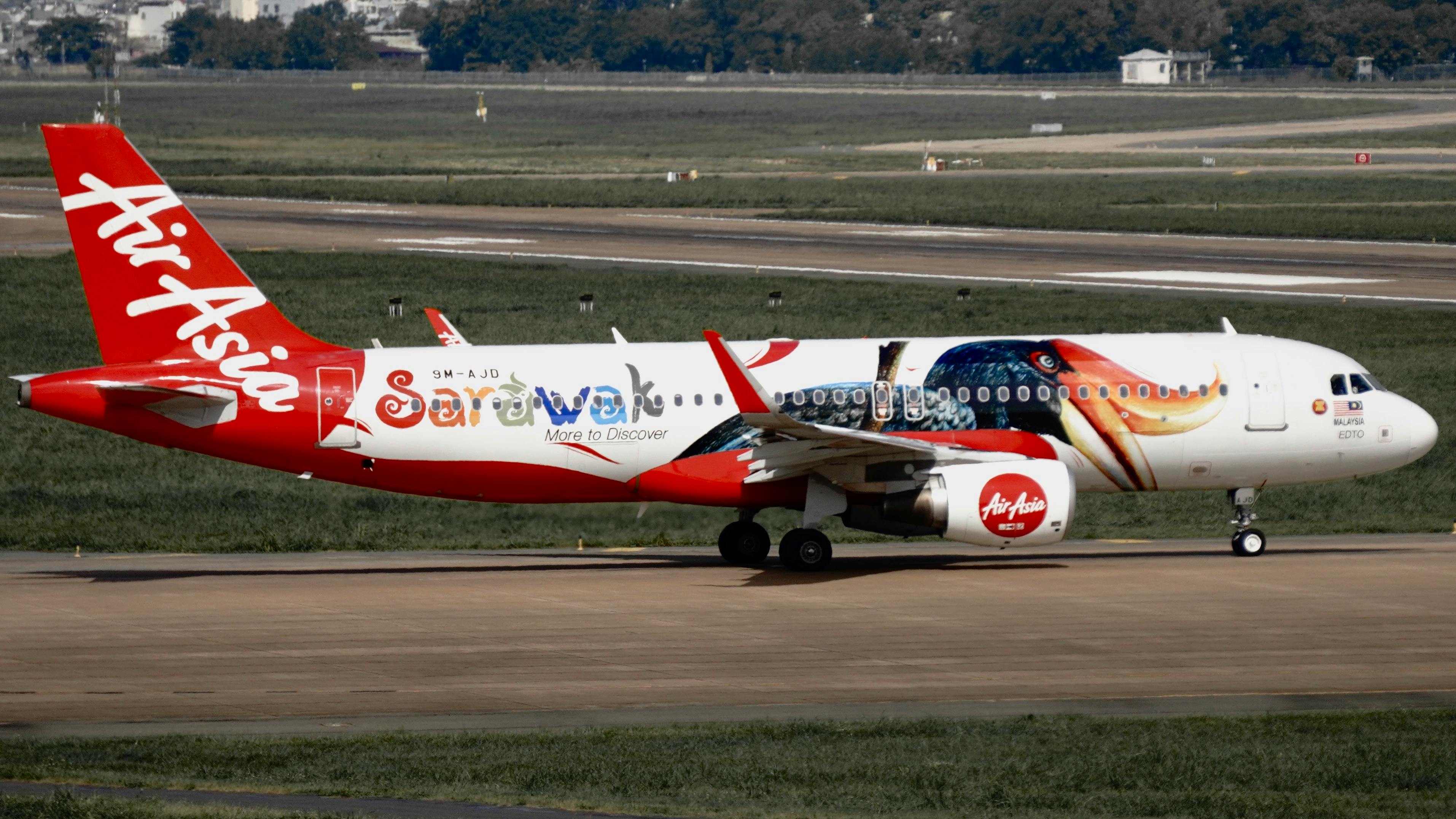 AirAsia airplane featuring Sarawak-themed livery on a runway at daytime. - Borneo