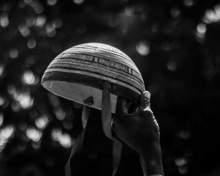 Black and white photo of a hand holding a helmet with artistic textures.