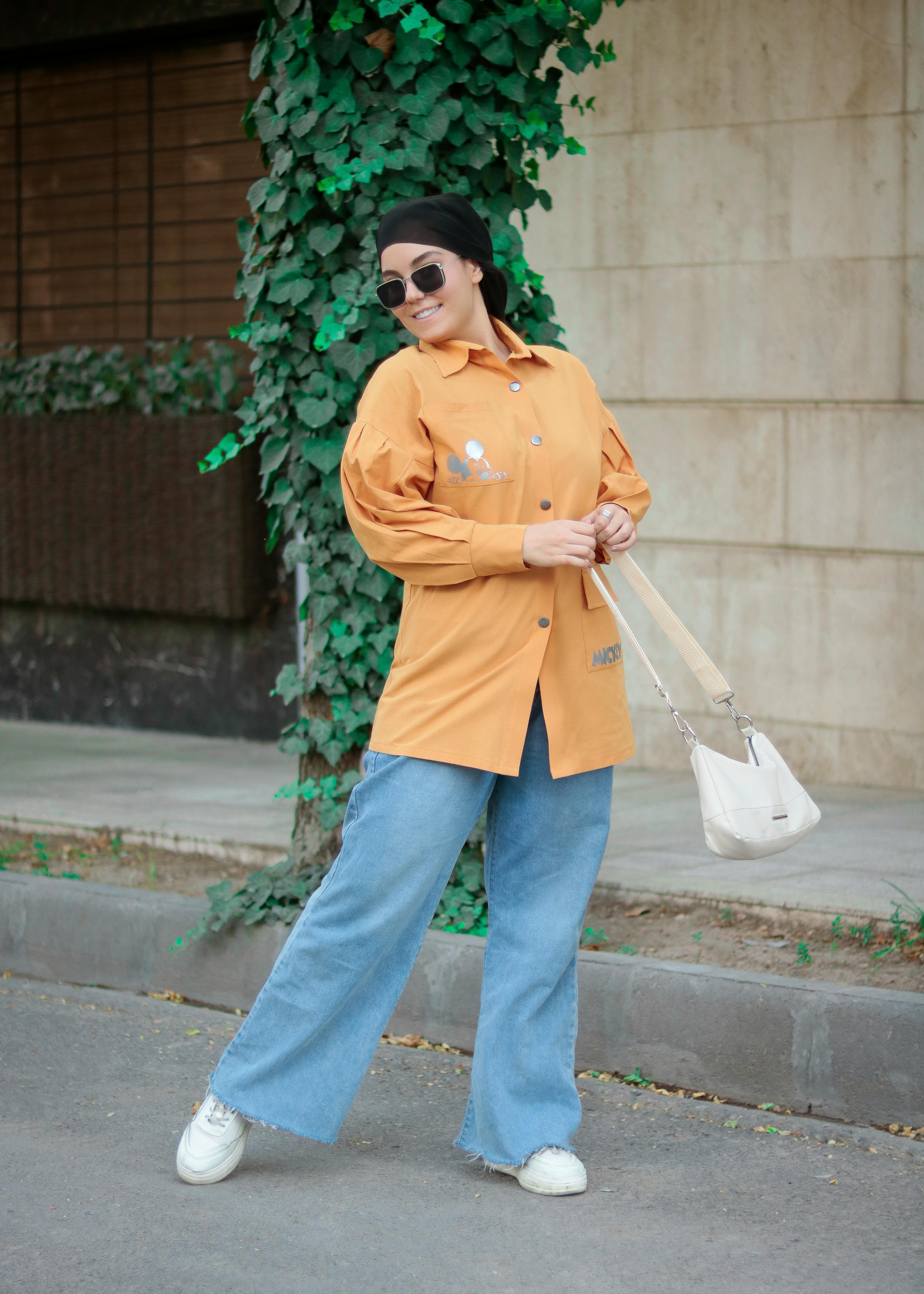 bezplatná Stylová žena pózuje venku v ležérním oblečení se slunečními brýlemi a moderním outfitu. Základová fotografie