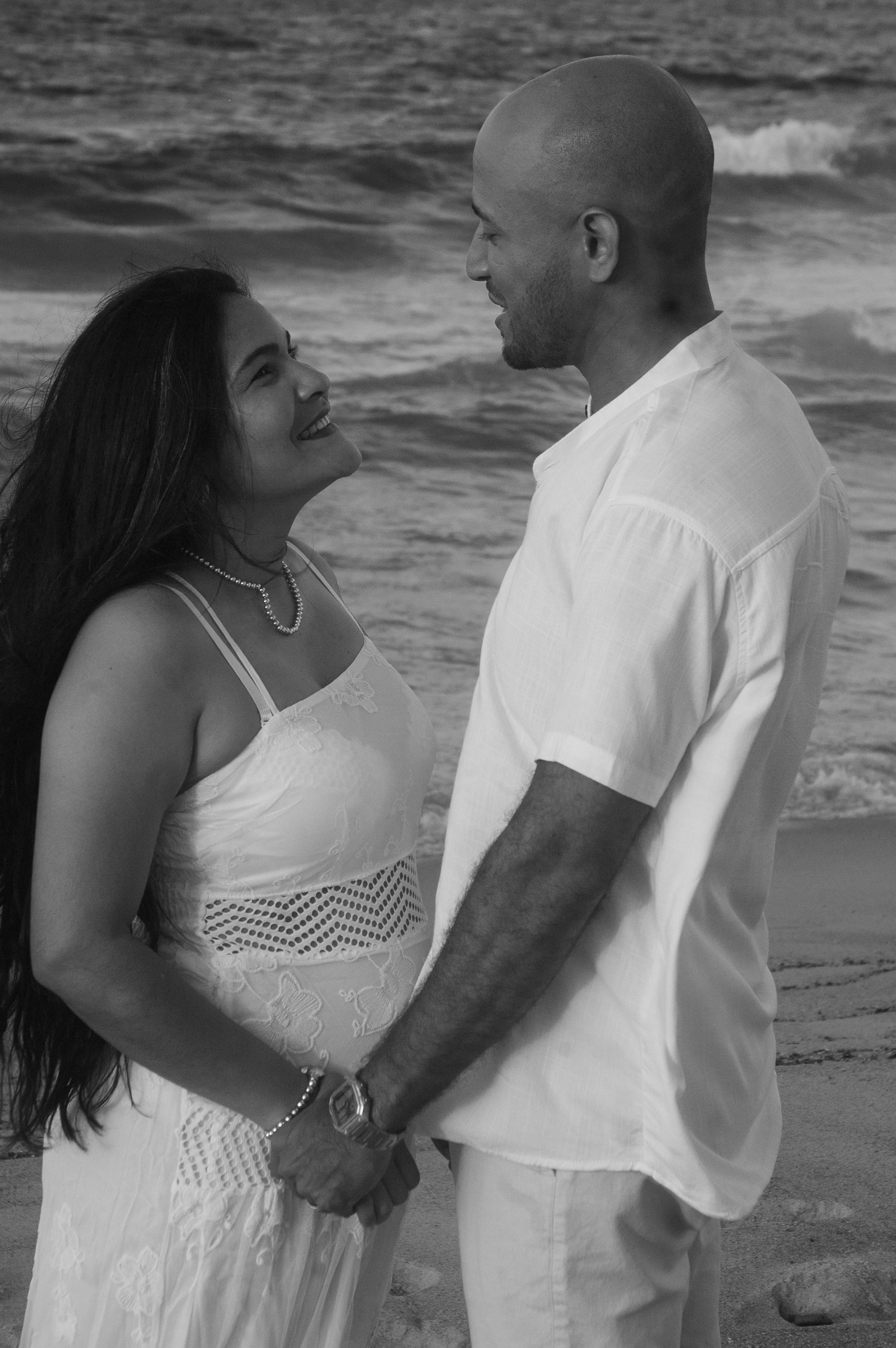 Couple se tenant la main sur une plage au coucher du soleil