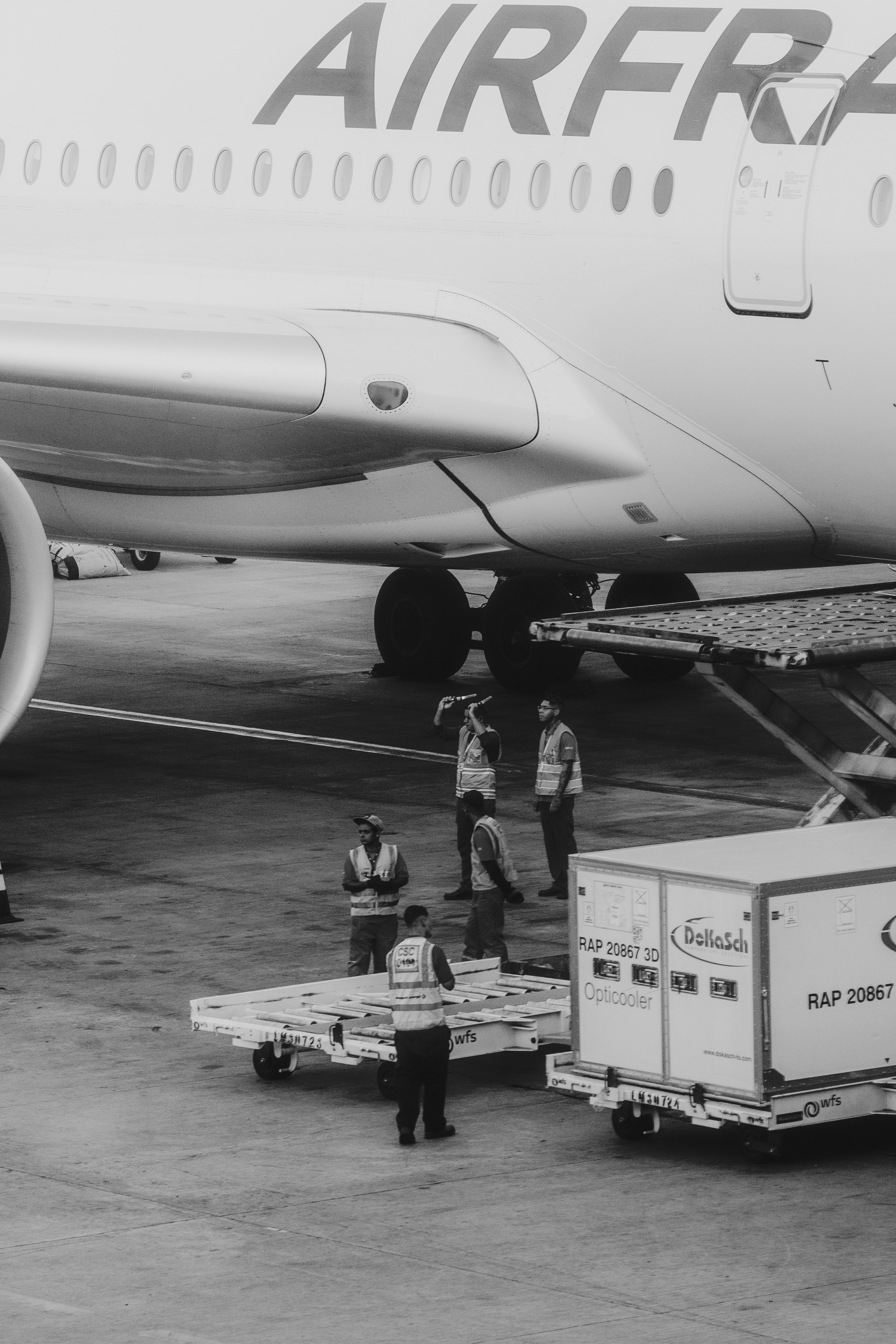 Ground crew loading cargo onto an airplane at the airport