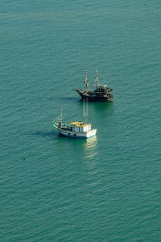 Scenic view of two boats on a serene sea in Brazil, captured at sunset.