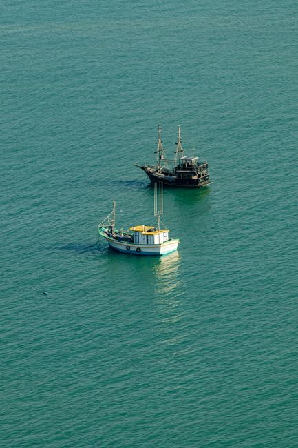 Scenic view of two boats on a serene sea in Brazil, captured at sunset.