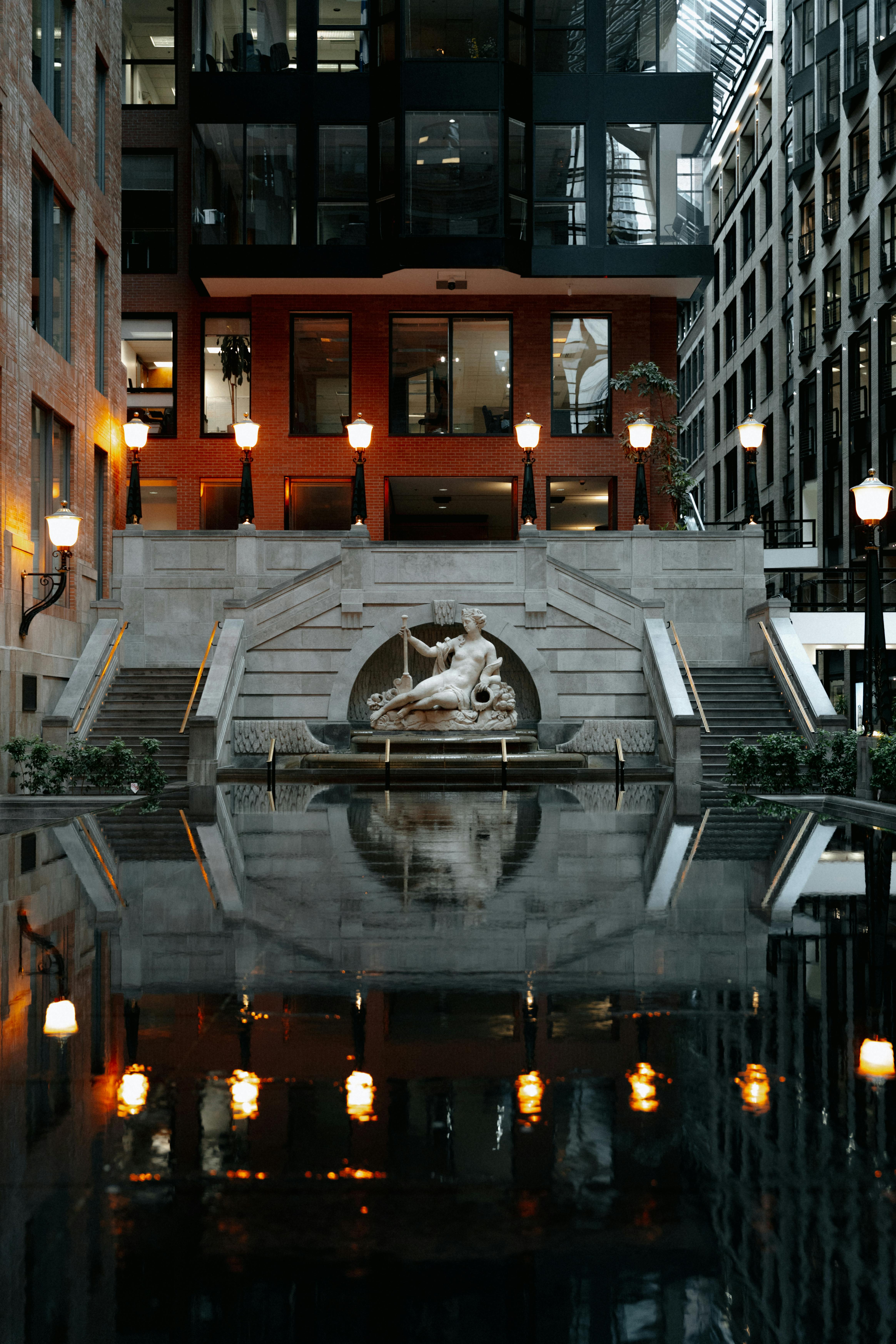 Reflective view of fountain and architecture in Montreal, capturing urban elegance and tranquility.