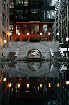 Reflective view of fountain and architecture in Montreal, capturing urban elegance and tranquility.