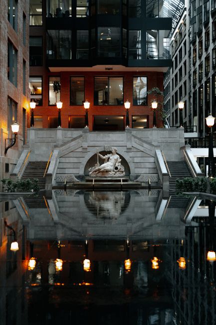 Reflective view of fountain and architecture in Montreal, capturing urban elegance and tranquility.