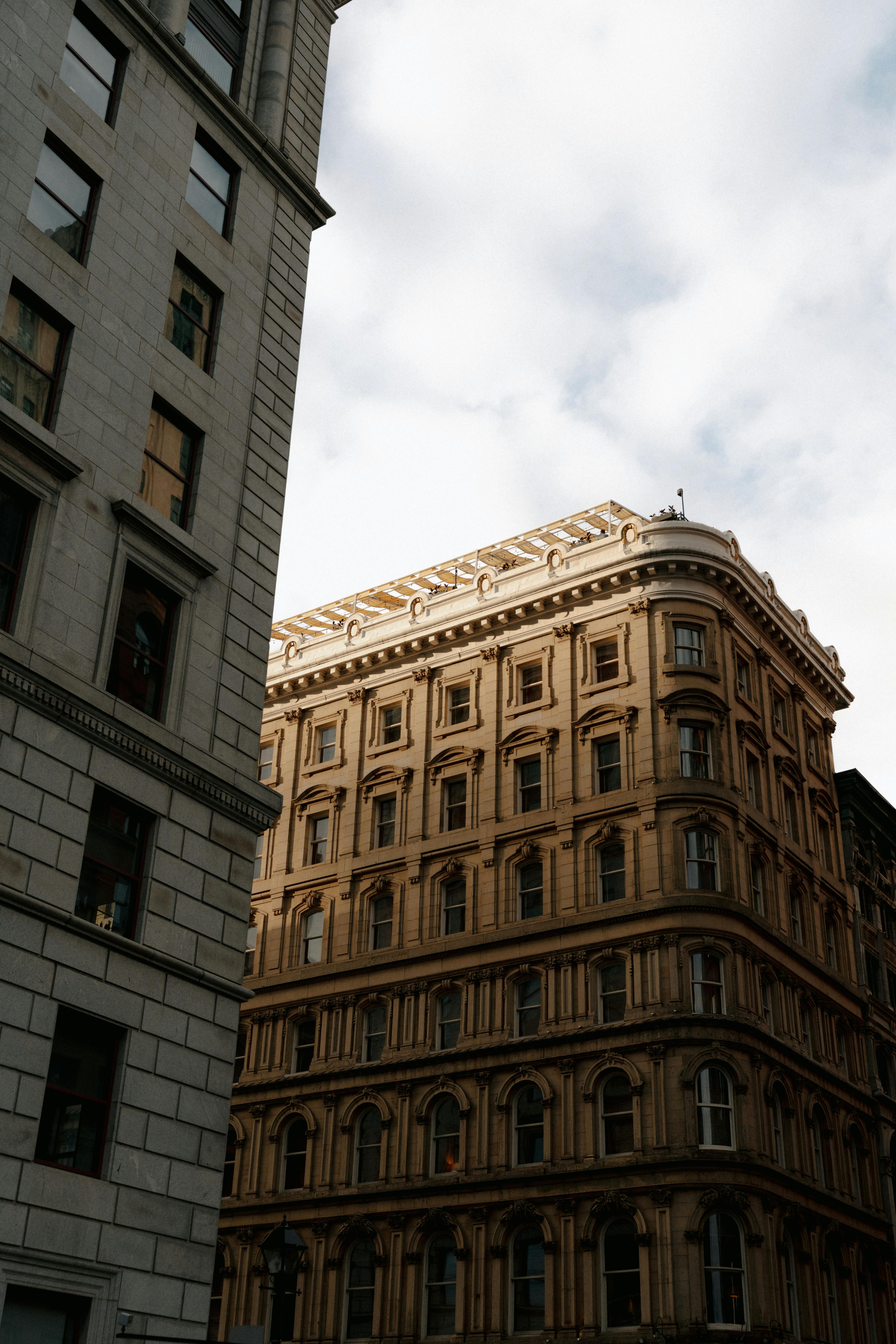 Capture of classic architectural buildings in downtown Montréal under a cloudy sky.