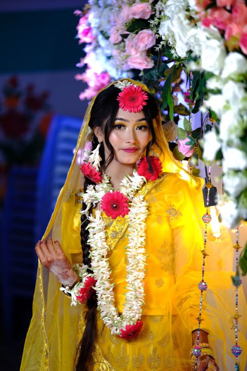 Free A stunning bride adorned in flowers and traditional yellow attire at a wedding ceremony. Stock Photo