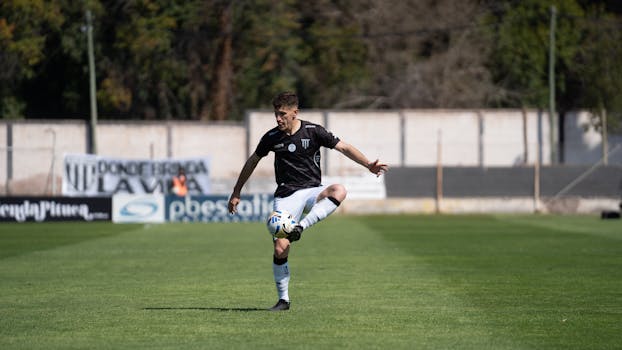 Focus on a young adult soccer player practicing ball control on the field.