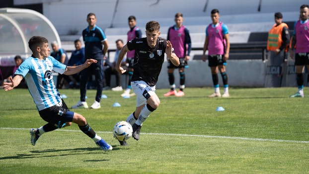 Two soccer players fiercely competing for the ball during a daytime match.