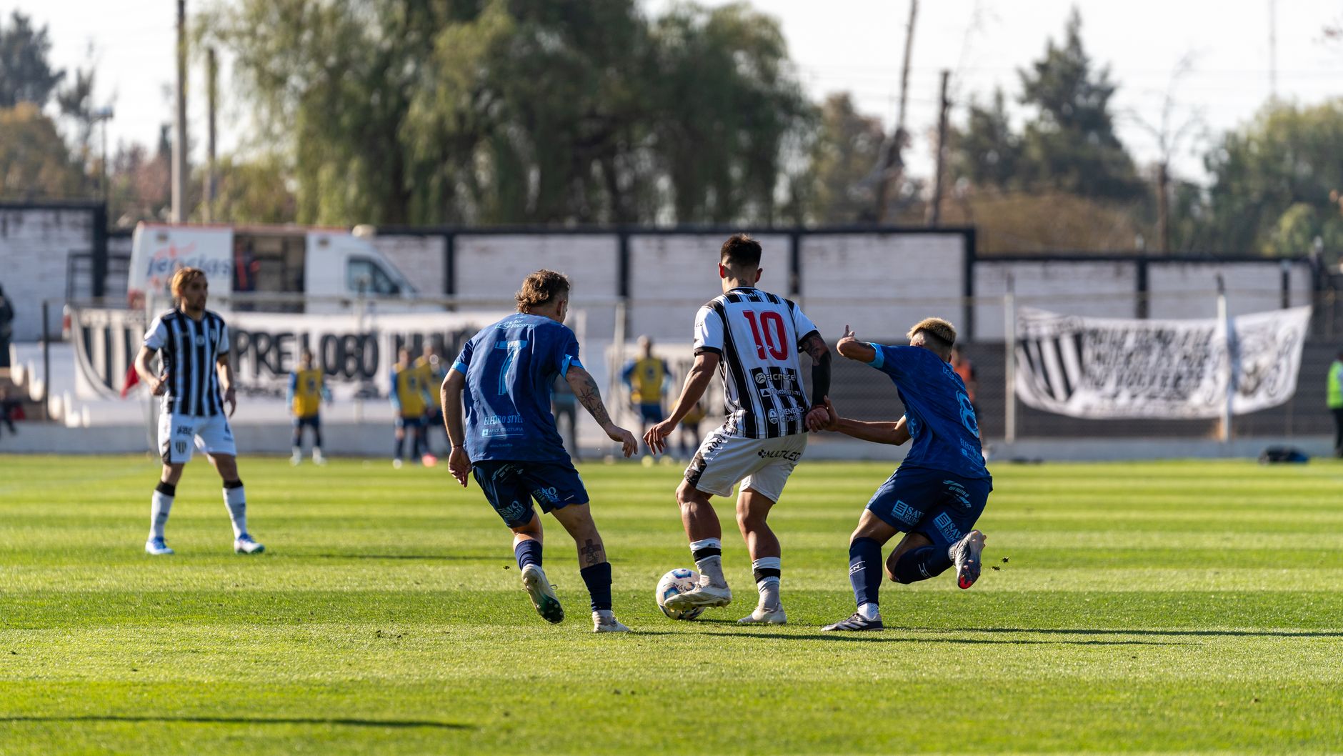 Players engaged in a competitive soccer match on a bright sunny day.