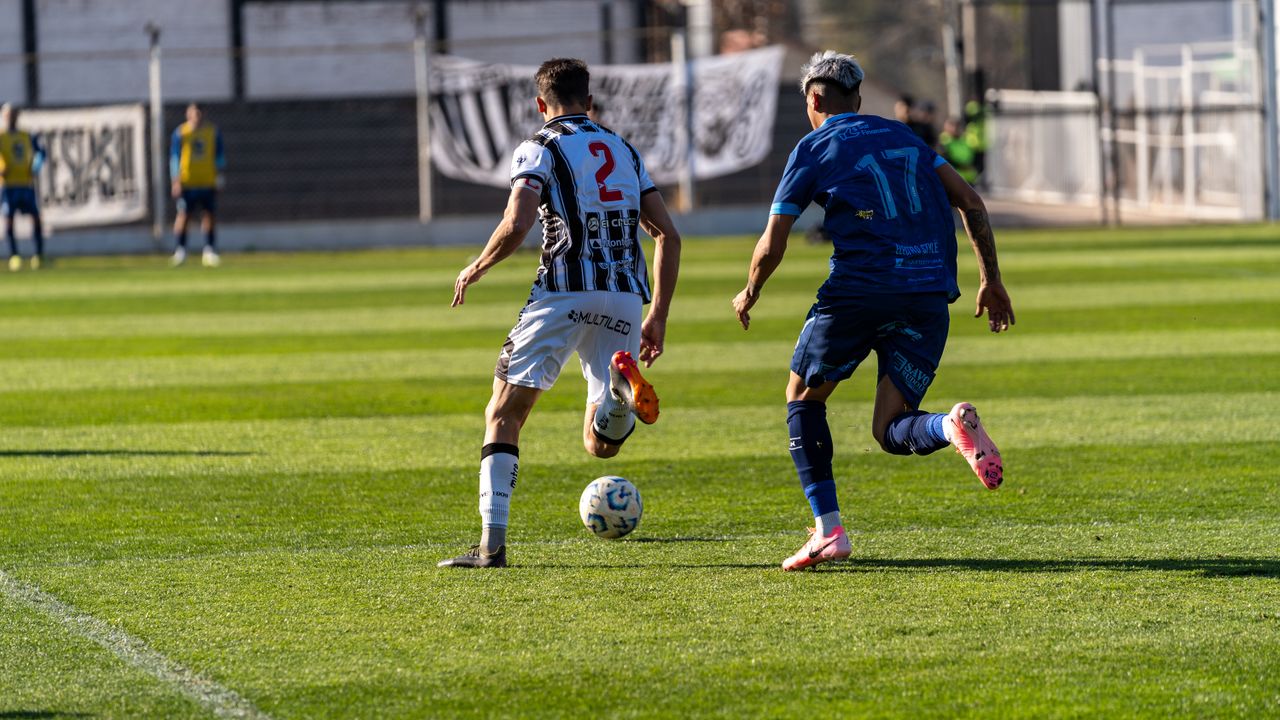 two soccer players compete fiercely on a sunny field showcasing athlet