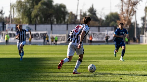 Players in action during a sunny soccer match, showcasing teamwork and athleticism.