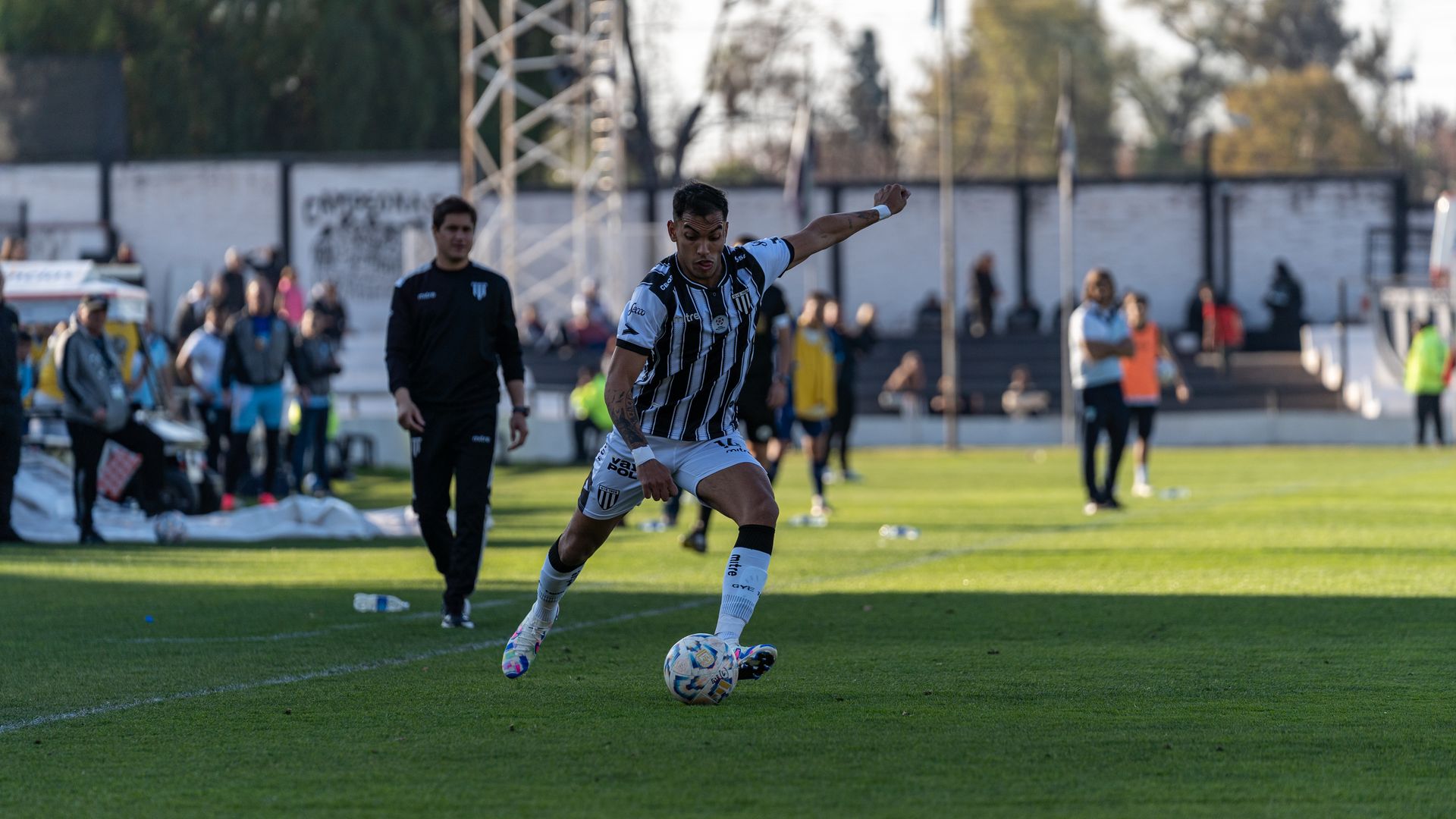 A football player in action on the field during an outdoor match, showcasing athletic skills.