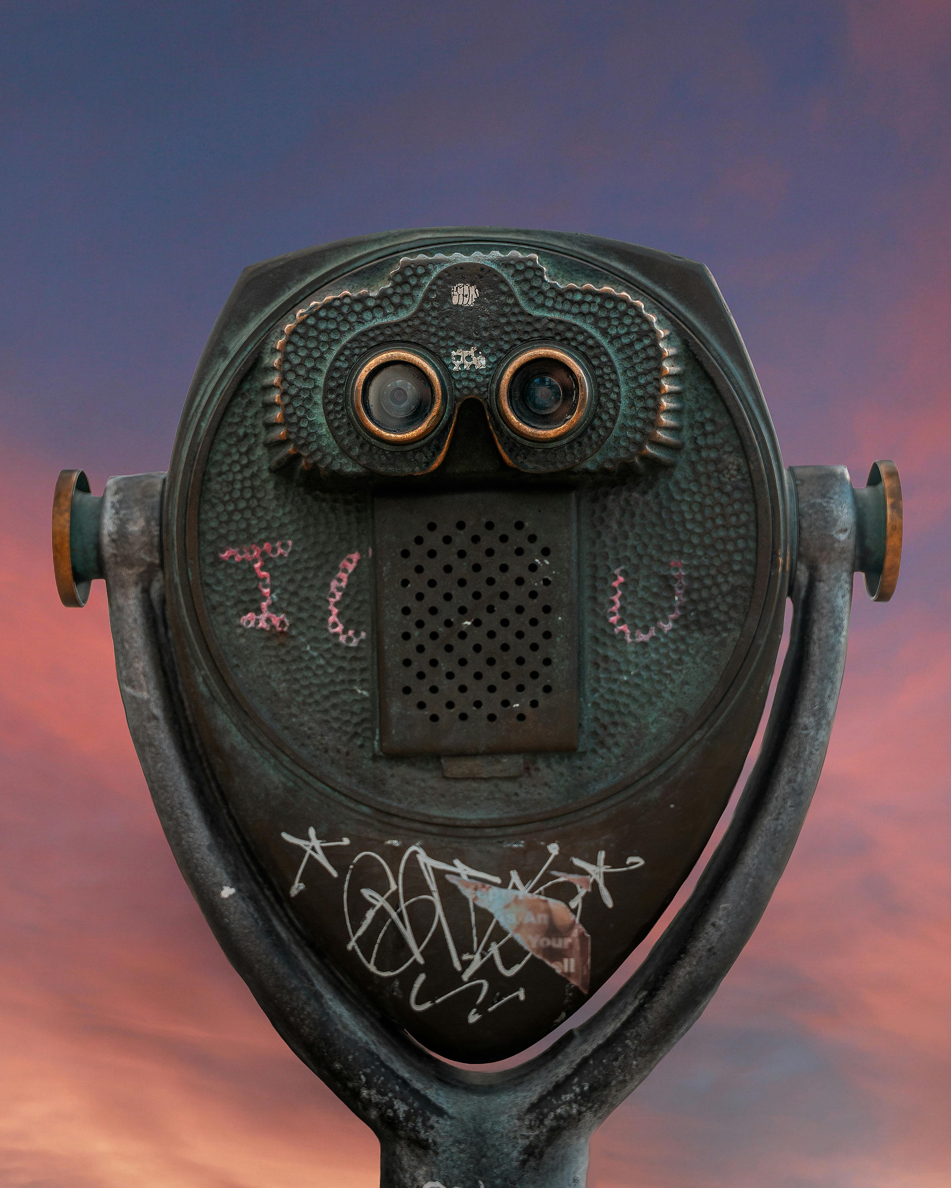 Kostenlos Ein Vintage-Sucher mit Graffiti vor einem farbenfrohen Sonnenuntergangshimmel. Stock-Foto