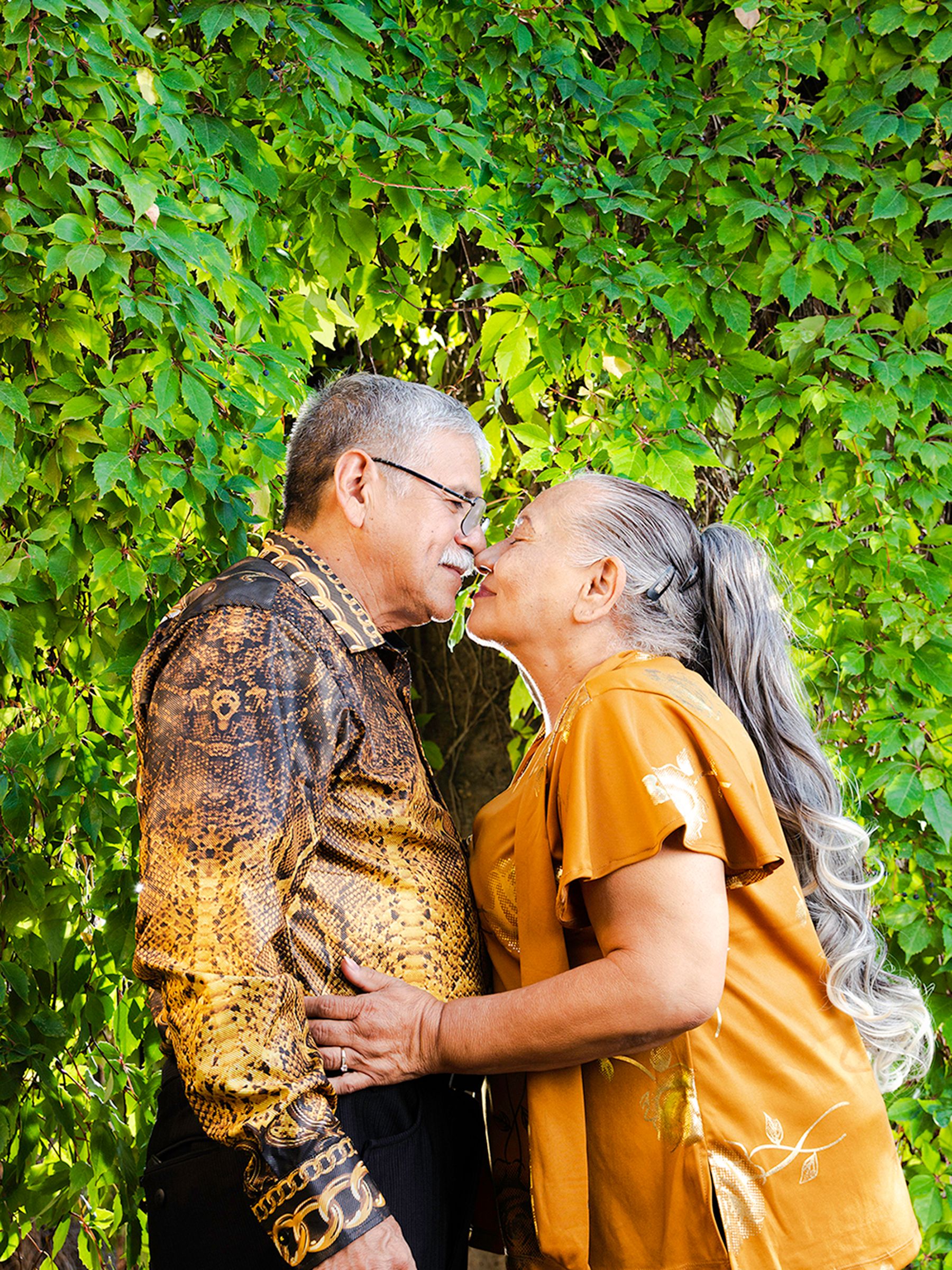 Romantic Elderly Couple Sharing a Kiss Outdoors · Free Stock Photo