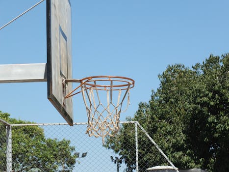 Outdoor basketball hoop on a court in Uberlândia, Brazil, under a clear blue sky.