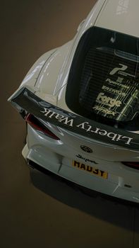 Overhead view of a sleek car with a Liberty Walk spoiler and custom decals.