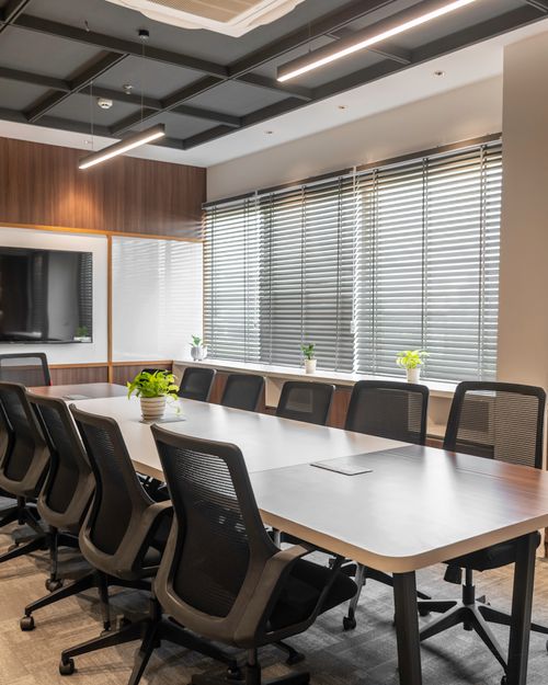 Free Sleek boardroom with conference table, chairs, and natural lighting in Sahibzada Ajit Singh Nagar. Stock Photo
