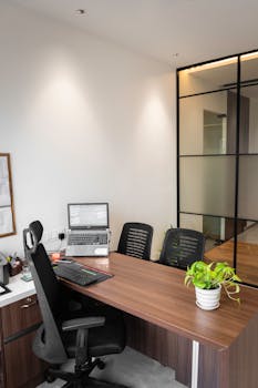 Contemporary office space featuring sleek wooden furniture and natural lighting.