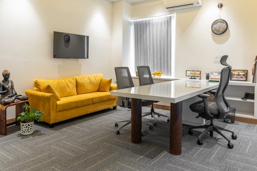 Contemporary office space featuring a yellow sofa, sleek furniture, and decor elements.