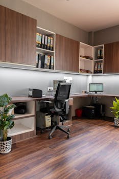 Stylish office setup featuring wooden cabinetry and modern furnishings. Ideal workspace inspiration.