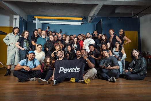 Large group of diverse photographers posing indoors with cameras.