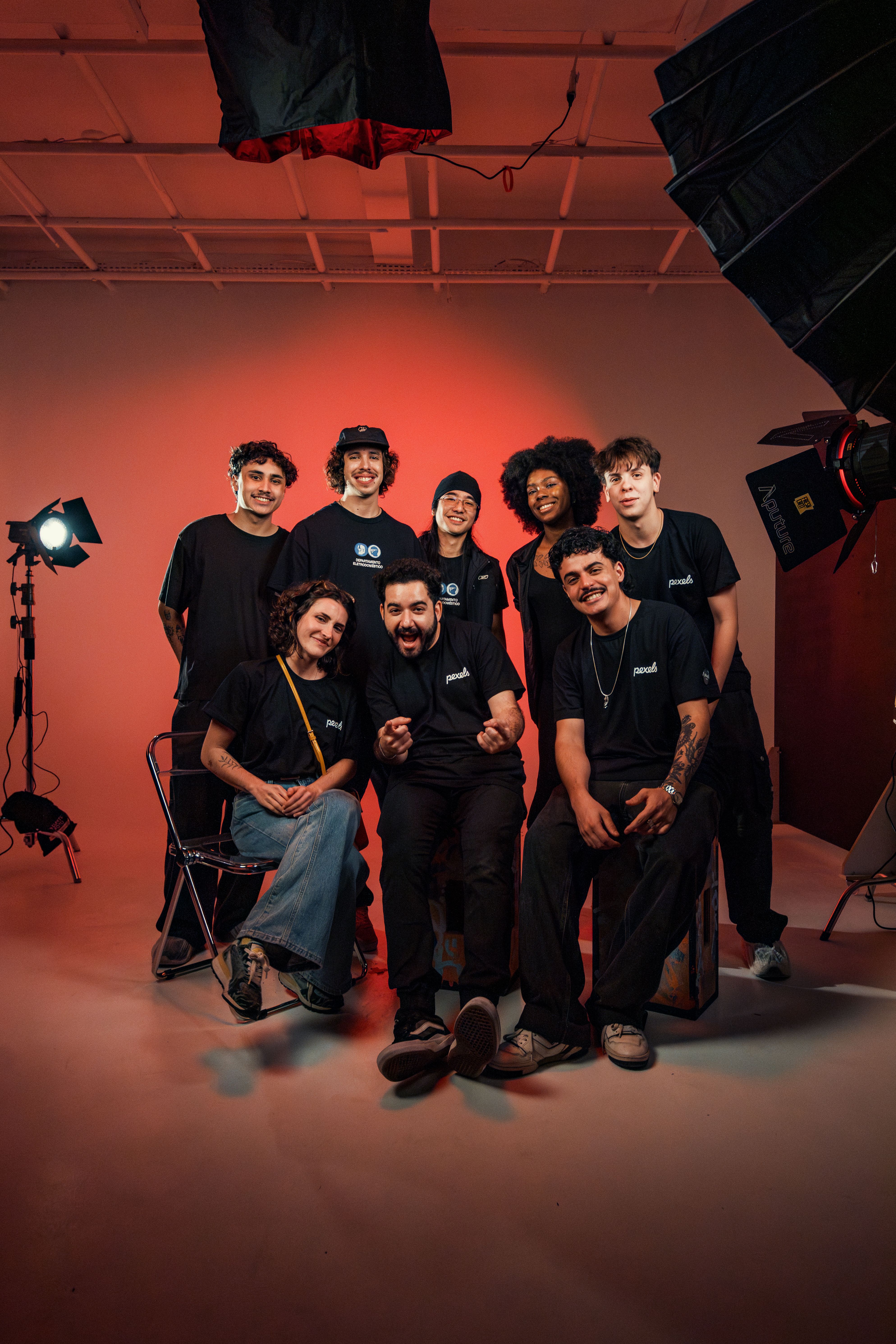 A diverse group of young adults in a studio setting, showcasing camaraderie and creativity.