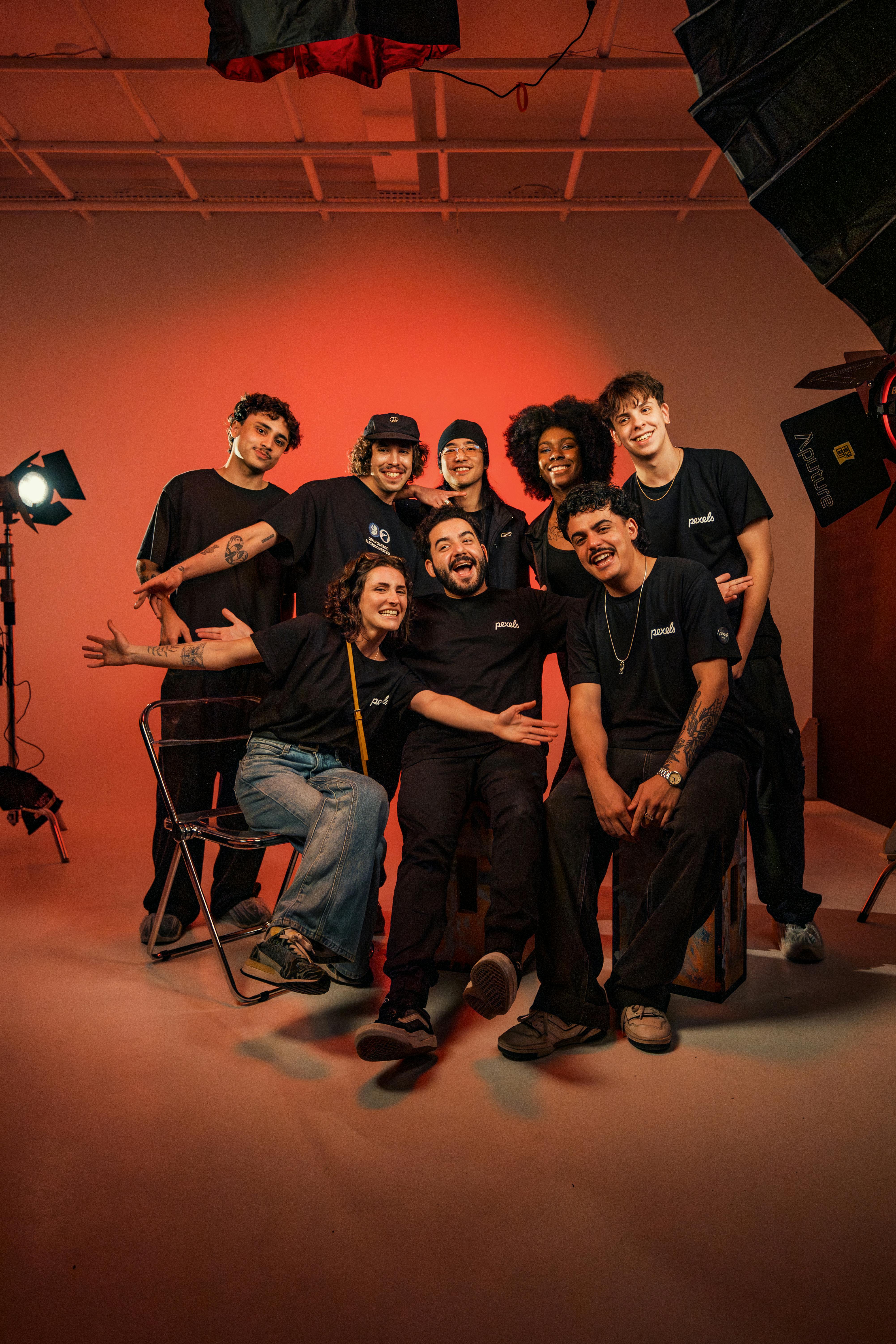 A diverse group of young friends joyfully posing in a photography studio with bright lighting.