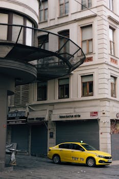 A yellow taxi parked at a historical street corner in Istanbul, showcasing classic architecture.