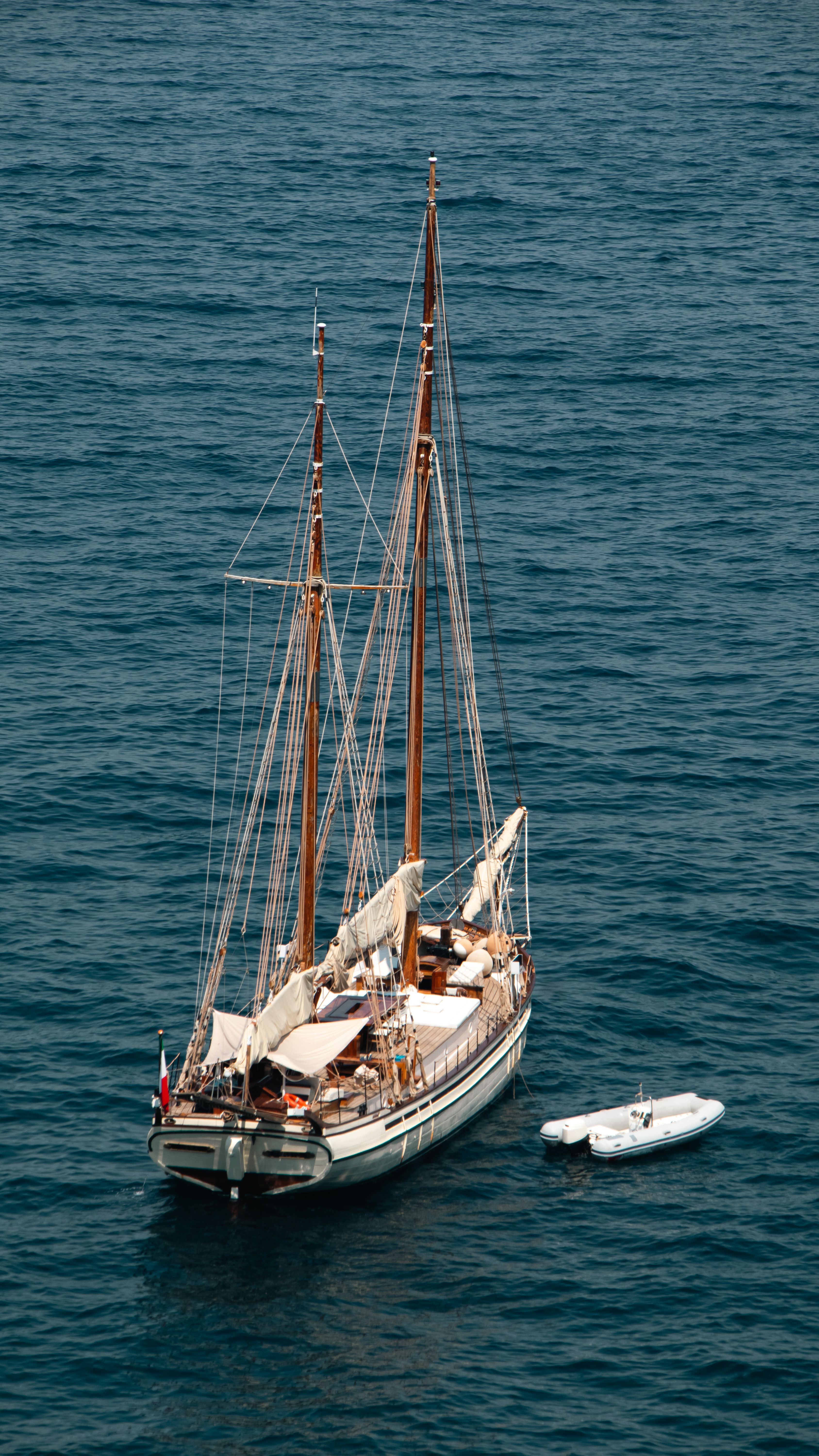 Sailboat gracefully floating on the tranquil waters off Sorrento, captured from above.