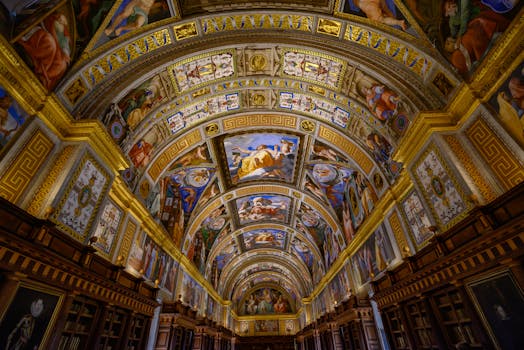 Intricate ceiling art of El Escorial Library in Madrid, Spain, showcasing classic artistic paintings.