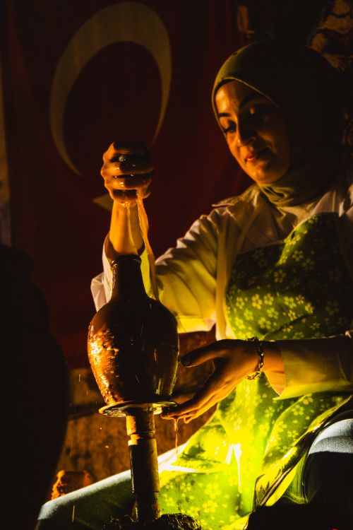 Free Turkish artisan shaping pottery with intense focus, illuminated by warm light. Stock Photo