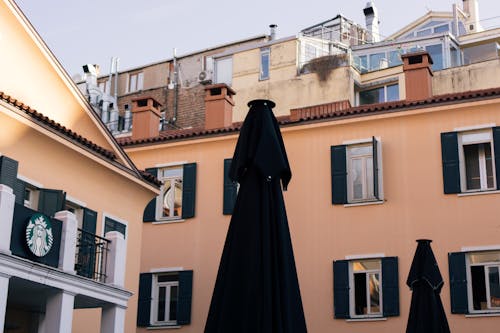 Outdoor view of a cozy Istanbul cafe featuring tall patio umbrellas and traditional architecture.
