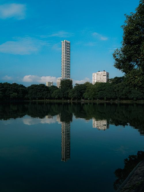Free Stunning reflection of modern skyscrapers in a tranquil pond, showcasing urban architecture in India. Stock Photo