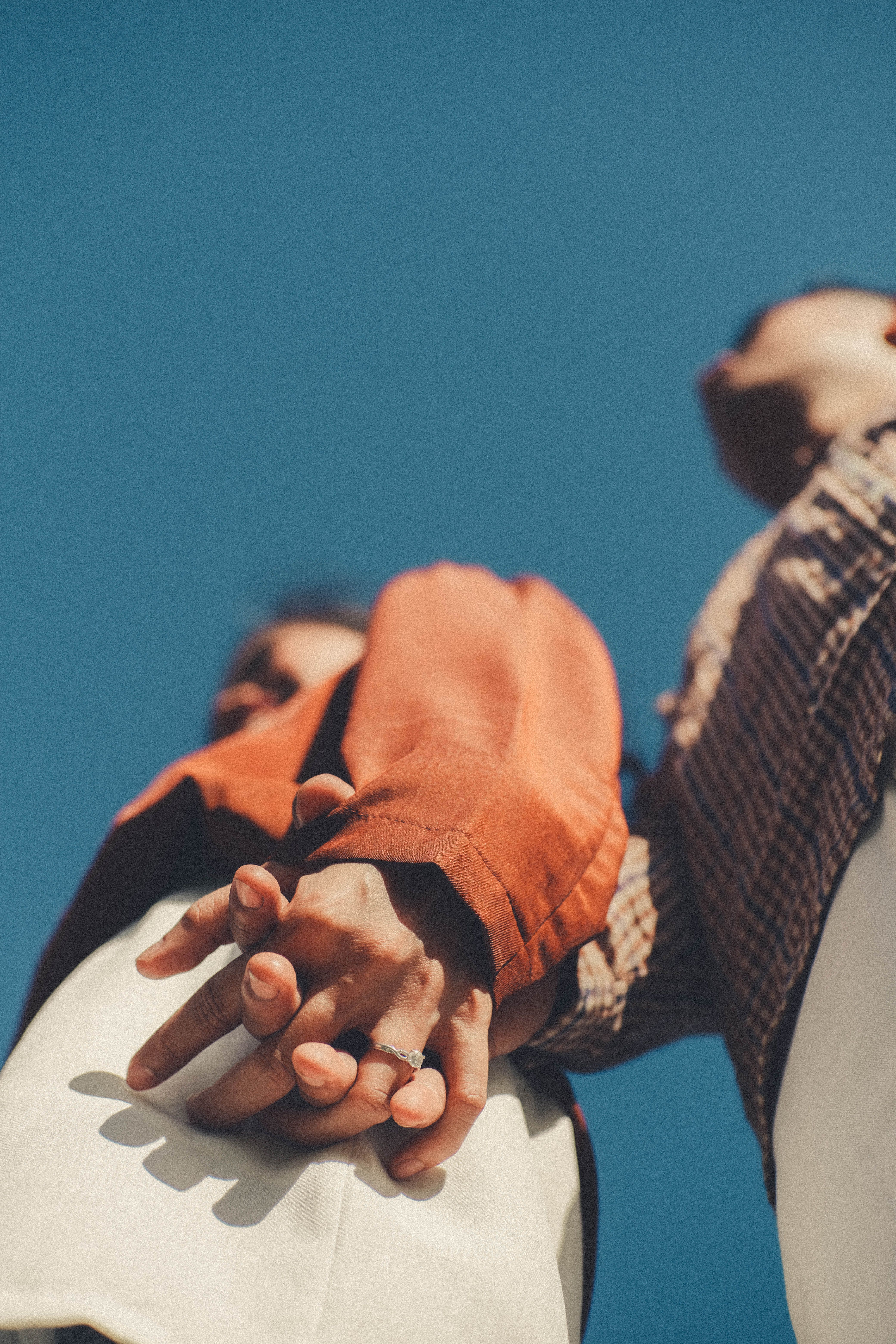 Low Angle View of Couple Holding Hands Against Blue Sky · Free Stock Photo