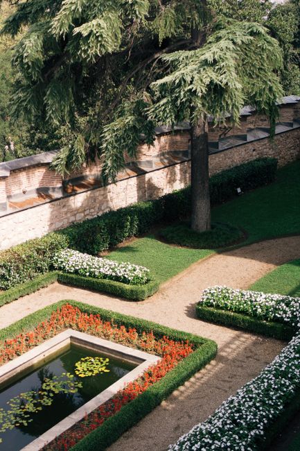 Beautiful garden view with vibrant flowers and a serene pond at Topkapı Palace in İstanbul.