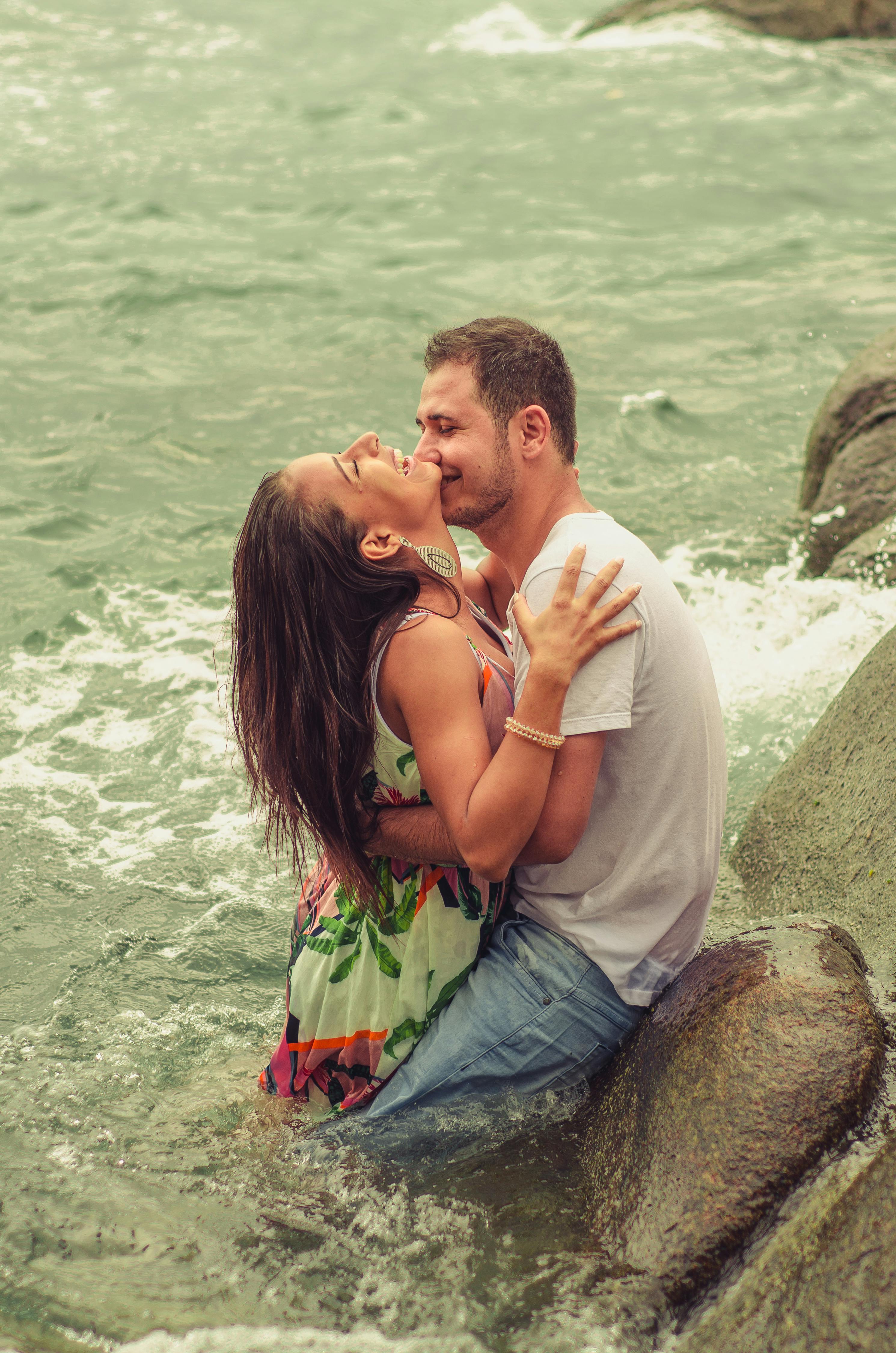 Man and Woman Hugging Each Other While Dipped in the Sea · Free Stock Photo