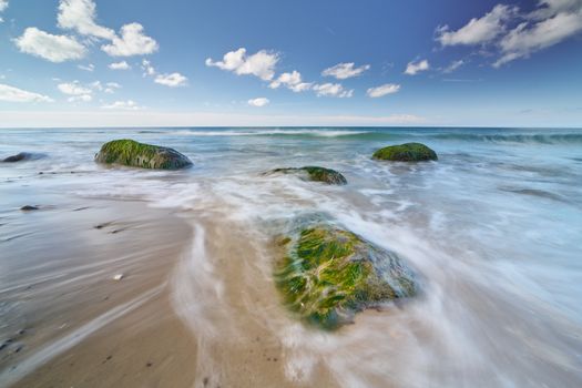 Stunning Hirtshals shoreline with algae-covered rocks and waves. Ideal for nature and travel themes.
