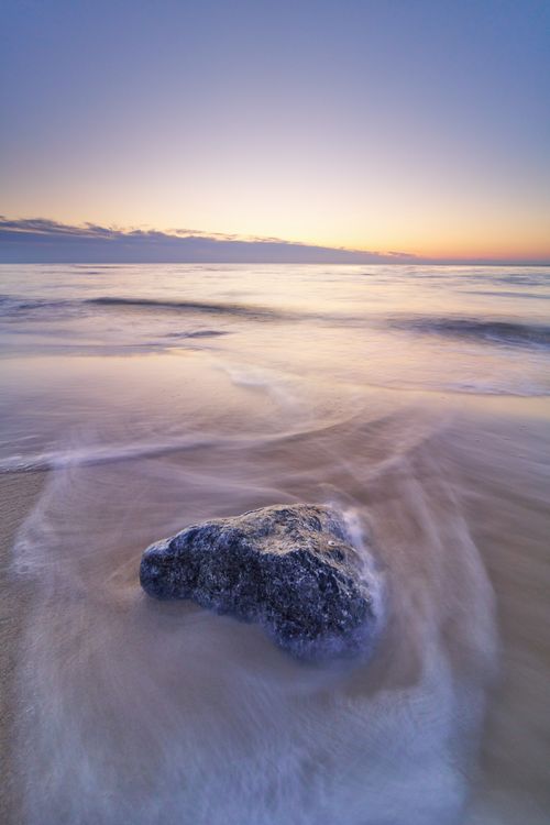 Free Captivating sunset on Hjørring beach with a solitary rock and gentle waves. Stock Photo