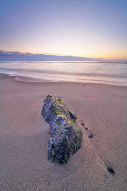 Free Peaceful sunset over a sandy beach with serene waters in Hjørring, Denmark. Stock Photo